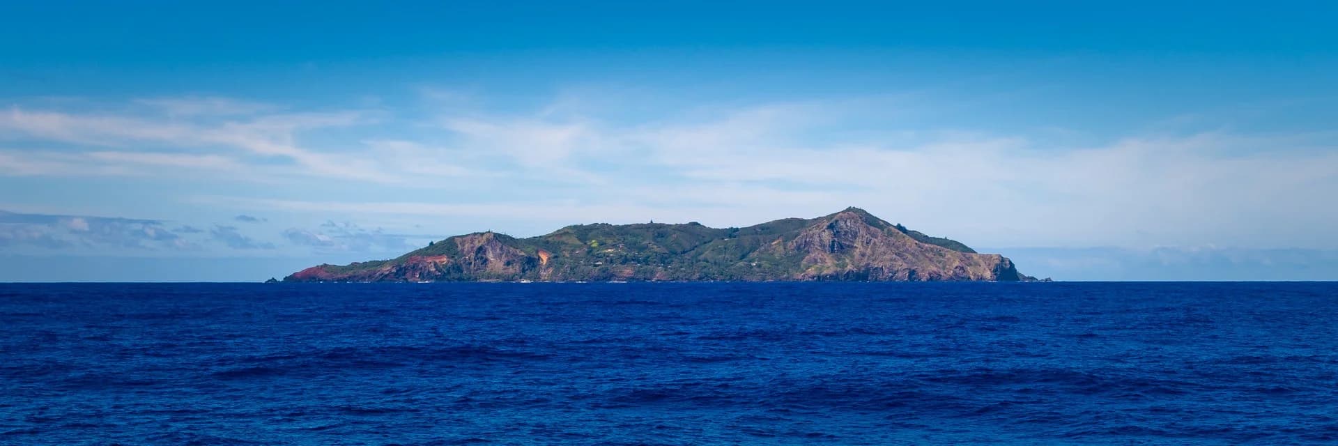 Pitcairn Island rising from a deep blue Pacific, seen from the sea
